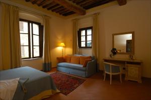 una camera da letto con un letto, una sedia e una scrivania di Le Vecchie Cantine a Chianni