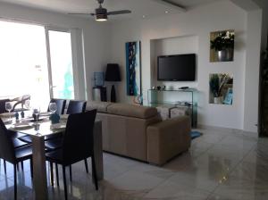 a living room with a couch and a table at Seafront Apartment With Pool in St Paul's Bay