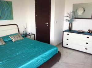 een slaapkamer met een blauw bed en een dressoir bij Seafront Apartment With Pool in St Paul's Bay +36 foto's