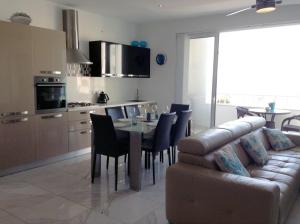 a kitchen and dining room with a table and a couch at Seafront Apartment With Pool in St Paul's Bay