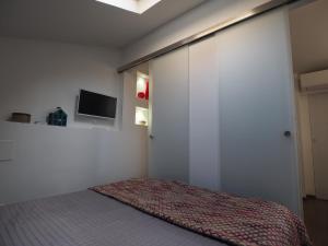 une chambre avec un lit et une télévision sur un mur dans l'établissement Tetti Rossi, à Bologne