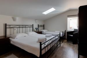 1 dormitorio con 2 camas con sábanas blancas y ventana en B&B Miracolo di Mare Retro, en Piran