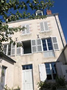 a building with white shutters on it at Suites du Cabinet Vert in Orléans