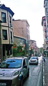 two cars driving down a city street with buildings at Kule Hotel in Bursa