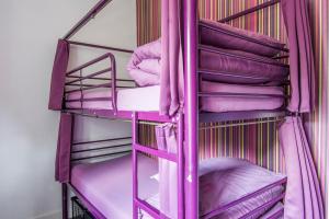 a bed room with a blue bedspread and a pink bedspread at Safestay London Kensington Holland Park in London