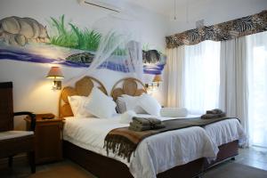a bedroom with a large bed with towels on it at Bhangazi Lodge Bed & Breakfast in St Lucia
