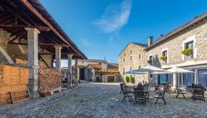 an outdoor patio with tables and chairs and umbrellas at Hotel Bernat de So in Llivia
