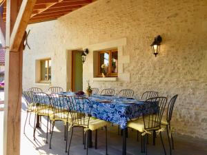 uma mesa com cadeiras e uma toalha de mesa azul em Boutique Farmhouse Cottages with Pool, 6 Bedrooms - Angulus Ridet (Loire Valley) em Chaveignes