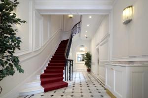 a staircase in a house with red carpeting and a red rug at 20 Hertford Street in London