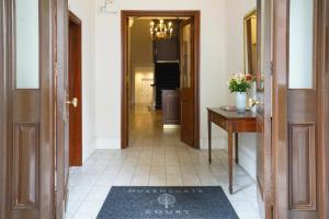 - un couloir avec une porte et un tapis au sol dans l'établissement Queensgate Court, à Londres