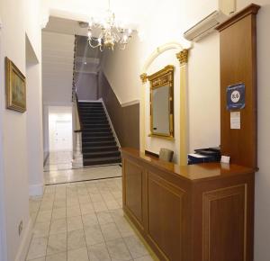 a hallway with a mirror and a staircase at Queensgate Court in London