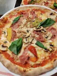 a pizza sitting on top of a white plate at Auberge de Ballens in Ballens