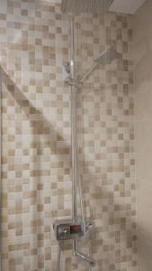 W łazience z wyłożoną kafelkami ścianą znajduje się prysznic. w obiekcie Rosalía de Castro, 41 - Centro - VUT-CO-01904 w Santiago de Compostela