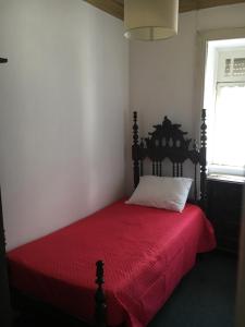 ペーゾ・ダ・レーグアにあるVivenda Branca Martinhoの赤いベッド1台(赤い毛布付)が備わるベッドルーム1室が備わります。
