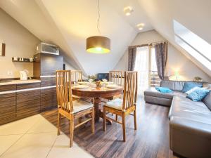 a kitchen and dining room with a table and a couch at VisitZakopane - Malibu Apartment in Zakopane