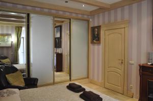 リヴィウにあるApartments in Lviv centerのベッド1台、椅子、鏡が備わる客室です。