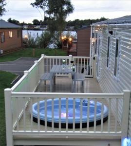 a deck with a table and a bench on it at Serenity Luxury Hot Tub Breaks in Tattershall