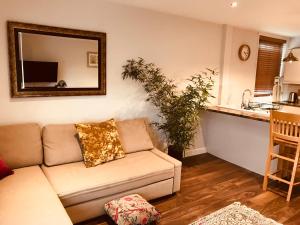 a living room with a couch and a mirror at Modern One Bedroom Apartment near the seafront in Portsmouth