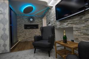 a living room with a bottle of wine and a chair at Wellness Apartmán Relax in Český Těšín