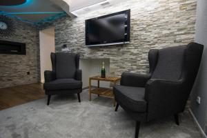 dwa krzesła i telewizor na murze. w obiekcie Wellness Apartmán Relax w Czeskim Cieszynie