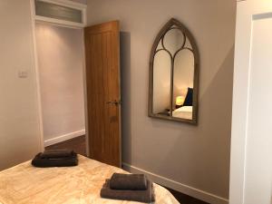a bedroom with a bed with a mirror on the wall at Modern One Bedroom Apartment near the seafront in Portsmouth