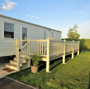 a mobile home with a porch and a wooden deck at Serenity Luxury Hot Tub Breaks in Tattershall