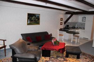 ein Wohnzimmer mit einem Sofa und einem Tisch sowie eine Küche in der Unterkunft Puppenstübchen in Wernigerode