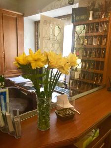 a vase of yellow flowers sitting on a counter at HOTEL Jerolitsch in Krumpendorf am Wörthersee