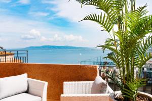 a balcony with chairs and a view of the water at Bike&Boat Argentario Hotel in Porto Santo Stefano