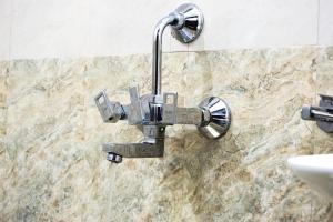 a shower head on a wall next to a sink at Hotel Kochi Crown in Cochin