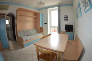 a room with a table and a room with a couch at Residence Villa Miky in Albenga