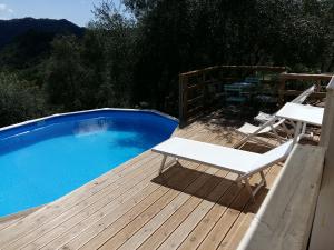 a deck with two chairs and a swimming pool at Valuable rustic Tuscan swimming pool, breathtaking view of Camaiore in Camaiore
