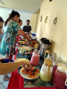 a group of people preparing food at a buffet at Pousada Recanto Setiba in Guarapari +31 photos