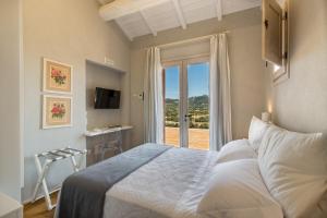 a hotel room with a bed and a tv at Tenuta Petra Bianca in Palau