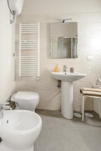 ein weißes Bad mit einem WC und einem Waschbecken in der Unterkunft Sorelle Partenope in Neapel