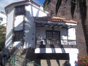 a white house with a balcony and a palm tree at Flor de Lis in Valle Gran Rey