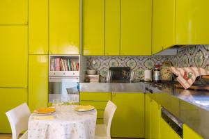 una cucina con armadi gialli e tavolo con sedie di Appartamento Il Giglio a Spoleto