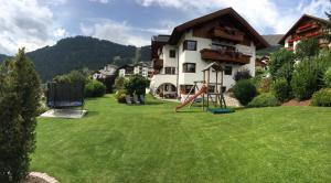 a large yard with a house and a playground at Apart Daniela in Fiss