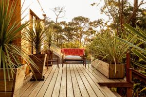 a wooden deck with a chair and a table at Wood House in José Ignacio