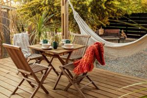 a wooden table and chairs on a deck with a hammock at Yaku Beach in José Ignacio