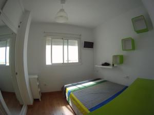 - une chambre avec un lit dans une pièce dotée d'une fenêtre dans l'établissement Tarifa Surf Center Apartment, à Tarifa