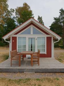 une cabine avec une table et deux chaises sur une terrasse dans l'établissement Askeviks Camping & Stugor, à Sjötorp