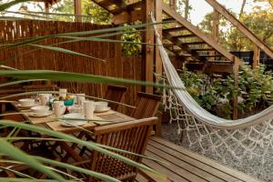 a hammock on a patio with a table and chairs at Zulu Beach in José Ignacio