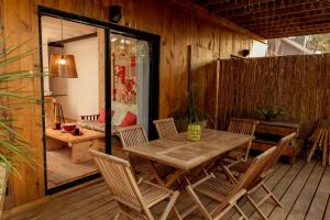 una terraza de madera con mesa y sillas de madera en Zulu Beach, en José Ignacio