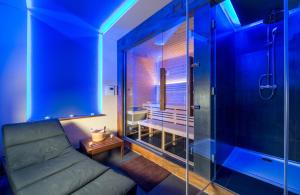 ウヘルスケー・フラジシュチェにあるホテル ムランスカのソファとガラス張りのシャワーが備わる客室です。