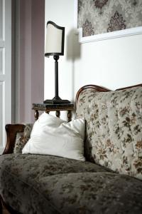 a lamp sitting on top of a couch with a pillow at Posti Apartment in Haapsalu