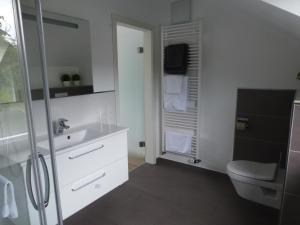 a white bathroom with a sink and a toilet at York Cottage Heaven in Traben-Trarbach