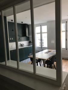 a kitchen with a table and a dining room at Appartement de charme in Saint Malo