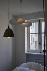 1 dormitorio con 2 luces, 1 cama y 1 ventana en Appartement de charme en Saint-Malo