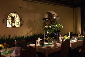 a dining room with a table with flowers on it at Hotel Storchen in Rheinfelden